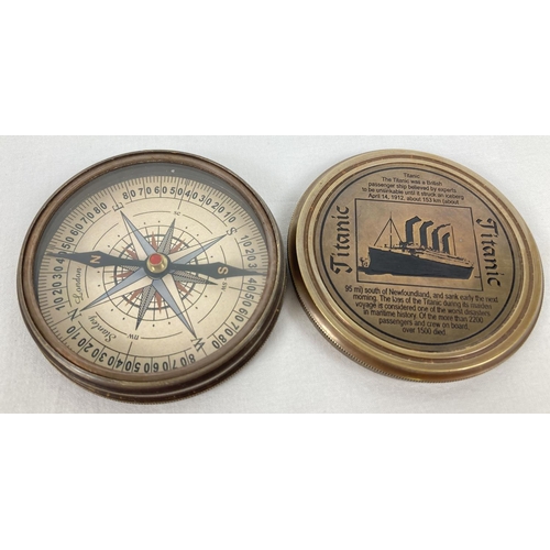 1327 - A brass cased compass with screw top lid featuring the Titanic. Picture and writing detail inside an... 