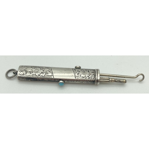 1084 - An antique silver propelling pencil and button hook. Floral engraving throughout with empty cartouch... 