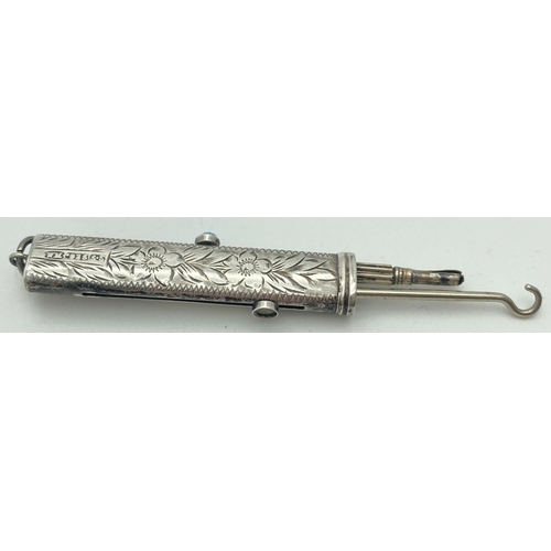 1084 - An antique silver propelling pencil and button hook. Floral engraving throughout with empty cartouch... 