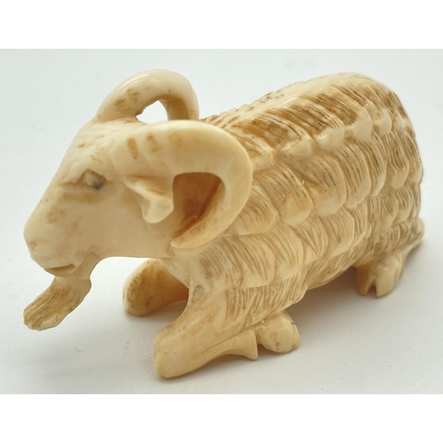 1333 - An Antique carved ivory figure of a long haired ram. Approx. 3.5 x 6cm.