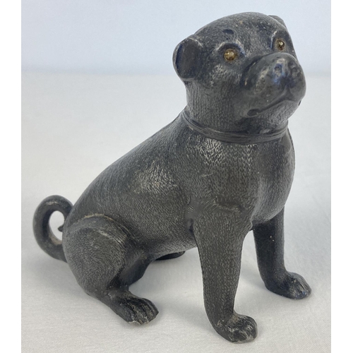 1108 - An antique pewter pounce pot modelled as a pug dog, with small amber glass eyes. Approx. 9cm tall.