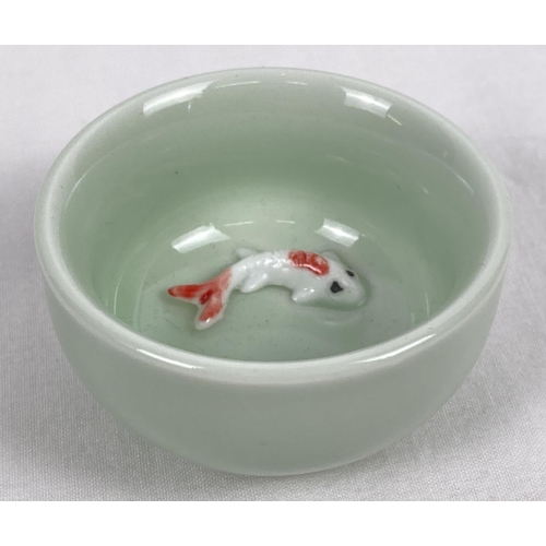 1203 - A small pale green glazed ceramic bowl with fish detail, in relief, to base of interior. Approx. 3.5... 