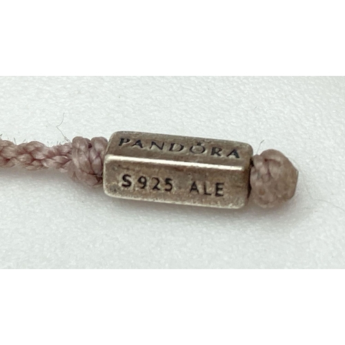 1154 - An adjustable lilac macramé bracelet by Pandora with silver fixings. Central clip bead with leaf pat... 