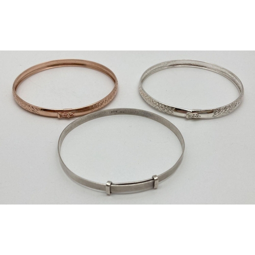 1130 - 3 silver bangles. Modern design silver and rose gilt matching patterned bangles with push clasps and... 