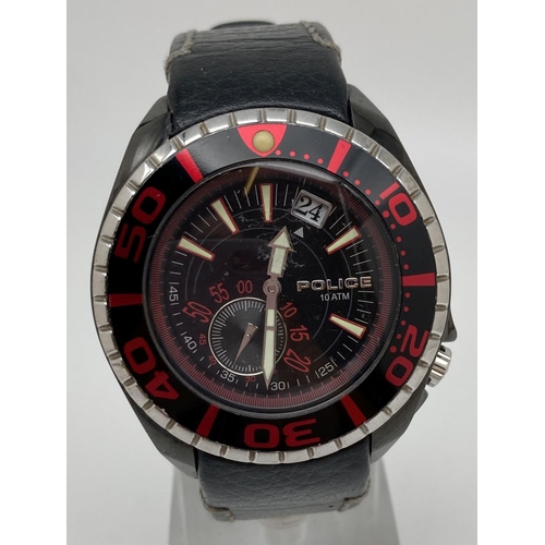 1170 - A men's 11182J wristwatch by Police with black leather strap. Black and red face. Luminous hand and ... 