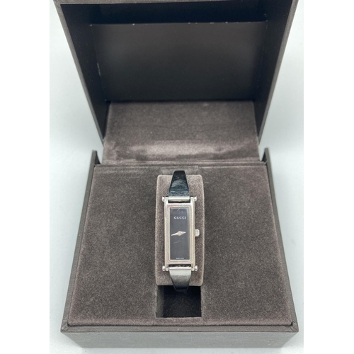 1174 - A boxed ladies 1500L silver tone stainless steel bracelet strap wristwatch by Gucci. Black face with... 