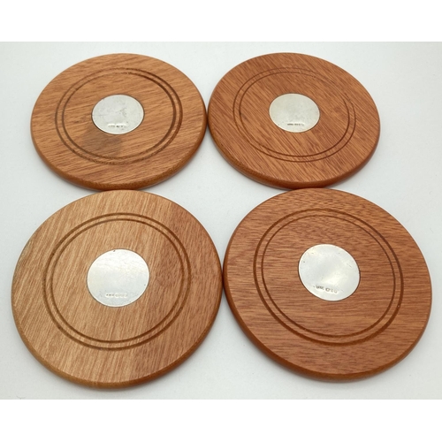 1189 - A set of 4 modern wooden coasters with silver panelled centres and baize undersides. Each hallmarked... 