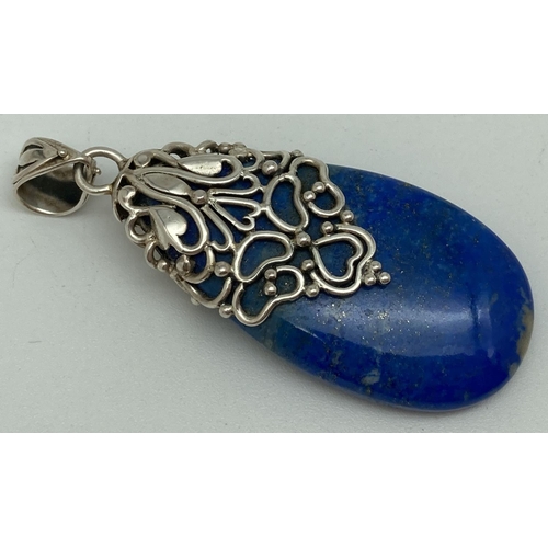 1115 - A large teardrop shaped lapis lazuli pendant with pierced floral and heart shaped silver overlay and... 