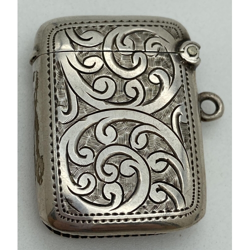 1193 - An Edwardian silver vesta case with engraved foliate & scroll detail front & back. Central empty shi... 