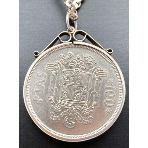 1093 - A silver Spanish 100 Ptas 1974 coin, in silver mount. On a 20 inch decorative belcher chain with spr... 