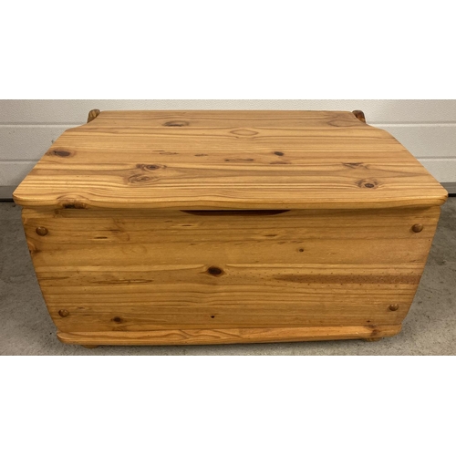 1399 - A vintage pine storage box with hinged lid and bun feet. Approx. 38cm x 72.5cm x 46cm.