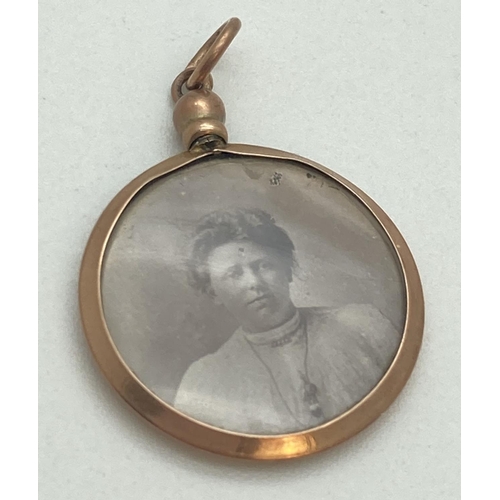 1089 - A Victorian 9ct gold circular shaped, double sided photo pendant. With hanging bale and interior pic... 