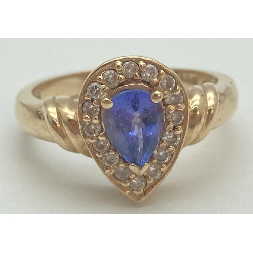 1091 - A 14ct yellow gold ring set with teardrop shaped tanzanite stone surrounded by diamonds. Set in a hi... 