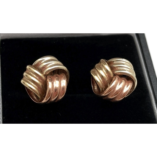 1109 - A pair of 9ct tri-coloured gold stud earrings in the form of knots. Complete with butterfly backs. E... 