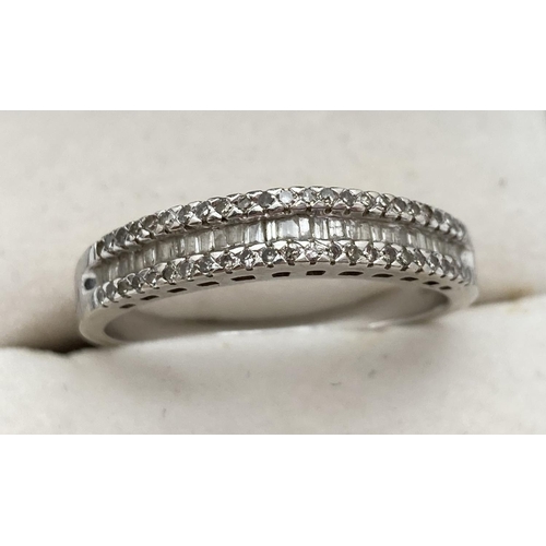 1112 - A 9ct white gold and diamond ring set with brilliant and baguette cut diamonds in a peaked setting. ... 