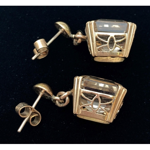 1118 - A pair of princess cut smoked quartz drop earrings in 9ct gold mounts. With decorative pierced work ... 