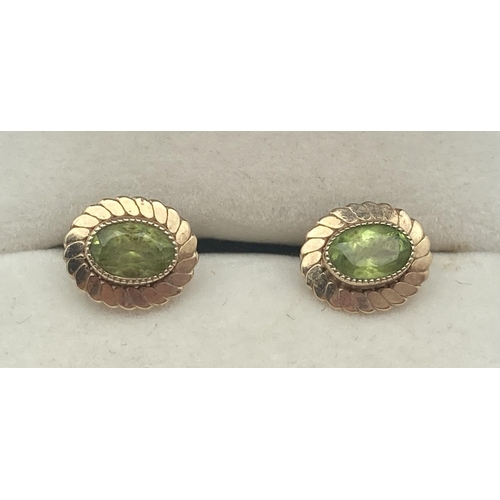 1119 - A pair of 9ct gold and peridot oval shaped stud earrings with twisted mounts. Test as 9ct gold. Comp... 