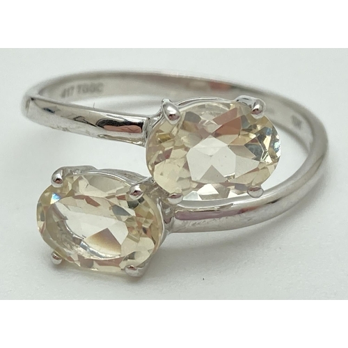 1129 - A 9ct white gold twist design 2 stone ring set with oval Serenite gemstones. Fully hallmarked inside... 