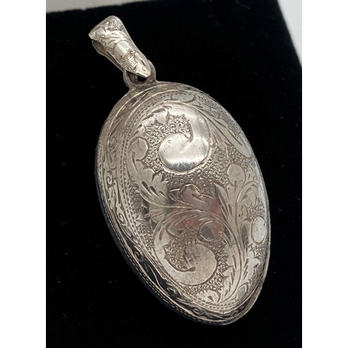 1133 - A vintage white metal egg shaped pendant with engraved scroll & foliate design to front & back. Bale... 