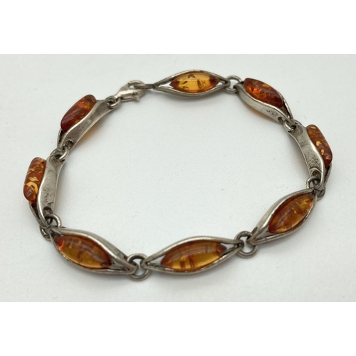 1138 - A 925 silver and amber bracelet with 8 long links. Stamped 925 to lobster claw clasp. Approx. 7