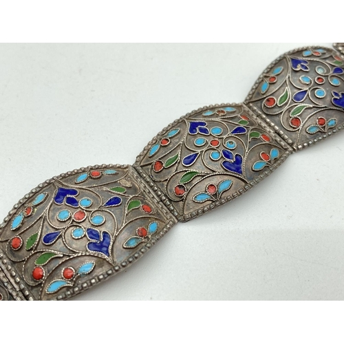 1156 - A vintage white metal hinge panelled bracelet with enamelled detail. Bayonet style clasp joins 5 cur... 