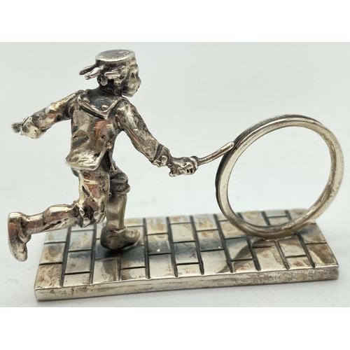 1206 - A small silver figurine of a Victorian child playing Hoop & Stick. Hallmarked to base with 925, make... 