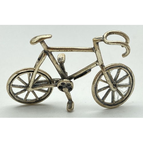 1208 - A Continental silver miniature model of a bicycle, with moving wheels. Stamped 800 to underside. App... 