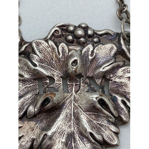 1210 - A vintage silver sherry decanter label together with a white metal rum label. Both with vine leaf de... 