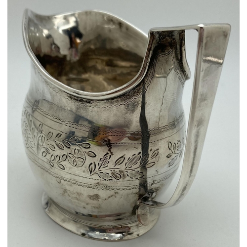 1219 - A Georgian silver cream jug with engraved floral banded design. Featuring a wreathed circular shaped... 