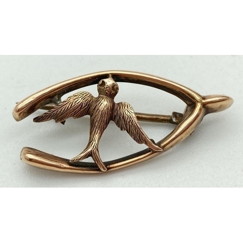 1114 - A vintage 9ct gold brooch in the form of a wishbone and swallow, with Chester hallmark. Approx. 3cm ... 