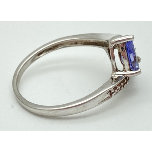 1034 - A 9ct white gold, tanzanite and diamond ring with a twist design setting. 2 teardrop shaped tanzanit... 