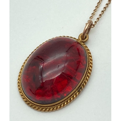 1007 - A vintage foil backed garnet mourning pendant in a 18ct gold rope design mount. On a later 17