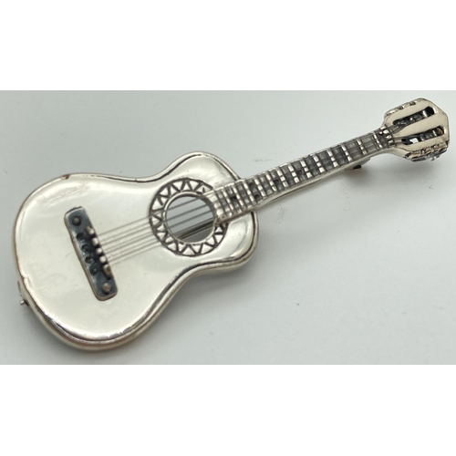 1050 - A 925 silver brooch in the shape of a guitar, complete with strings. Hallmarked to reverse. Approx. ... 