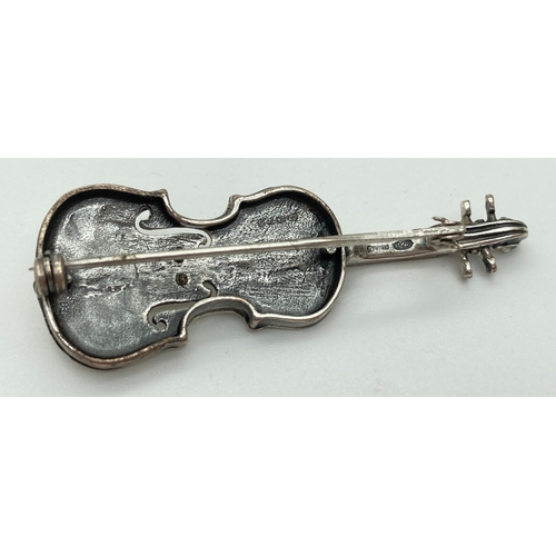 1051 - A 925 silver brooch in the shape of a violin, complete with strings. Hallmarked to reverse. Approx. ... 
