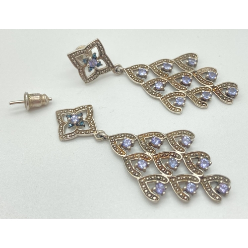 1066 - A pair of chandelier style drop earrings each set with 10 tanzanite and 4 london blue topaz stones. ... 