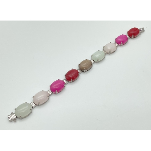 1076 - A 925 silver and coloured quartz link bracelet with open box clasp. 9 links sets with oval cabochons... 