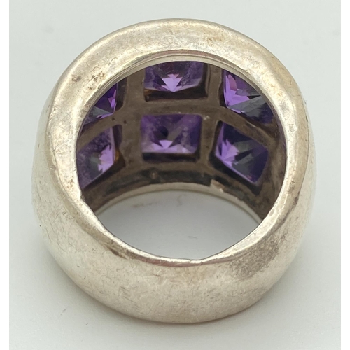 1077 - A chunky 925 silver dress ring set with 6 square cut amethyst stones. Ring size N, band width approx... 