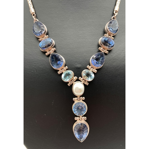 1078 - A 925 silver and blue stone set fixed pendant statement necklace with T bar toggle clasp. Articulate... 