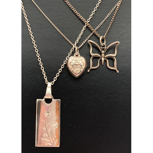 1089 - 3 silver and white metal pendant necklaces. A rectangular shaped pendant with floral engraved detail... 