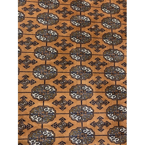 1417 - A large ochre coloured Indian style rug with brown, black and cream colours in a geometric design. T... 