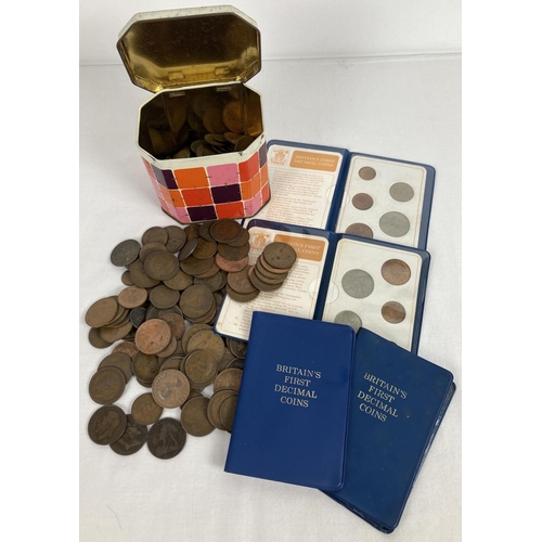 1220 - A small tin of vintage British coins mostly pennies and half pennies. Together with 4 Britain's Firs... 