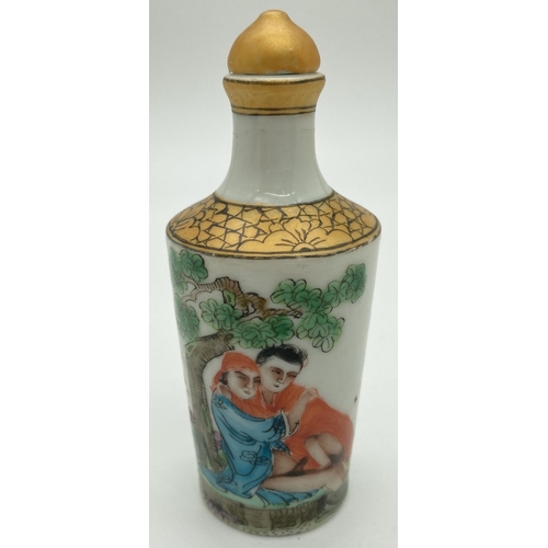 1301 - A small Chinese ceramic snuff bottle with painted erotic scene. Gilt painted stopper and top rim. Ha... 