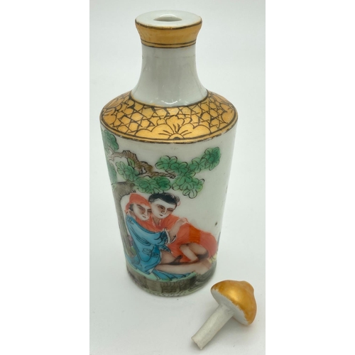 1301 - A small Chinese ceramic snuff bottle with painted erotic scene. Gilt painted stopper and top rim. Ha... 