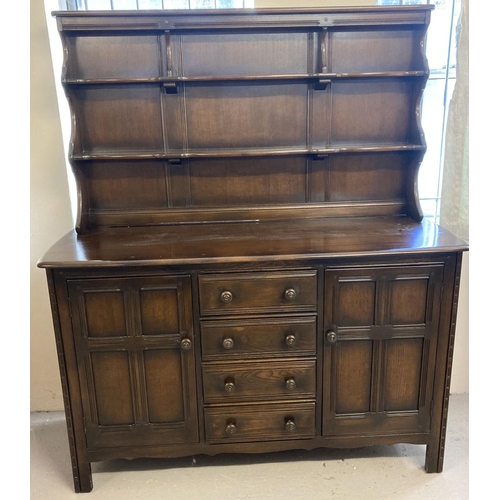 1432 - A vintage Ercol dark wood triple dresser with 2 door, 4 drawer base. With plate rack shelving top se... 