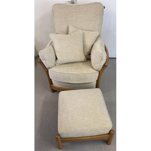 1443 - A modern Ercol light elm framed armchair and matching footstool, with cream coloured cushions. With ... 