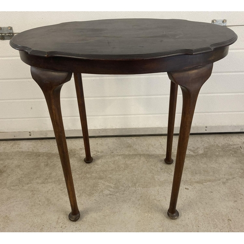 1448 - An Edwardian dark wood oval topped occasional table with straight legs, bun feet and shaped top. Som... 