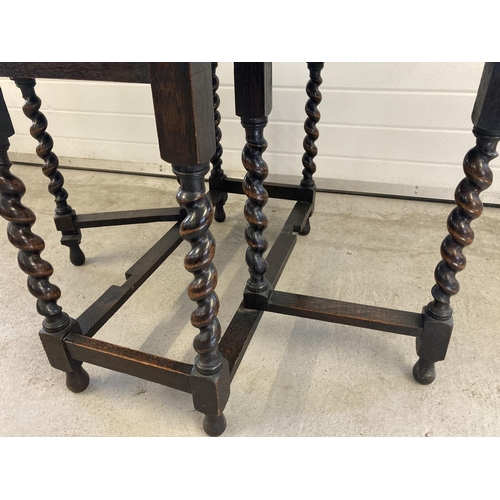 1454 - A Victorian dark oak barley twist drop leaf, gate leg dining table. With oval shaped top and bun fee... 