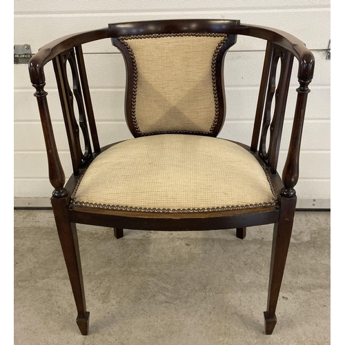 1455 - An Edwardian curve backed tub chair with tapered front legs and spade feet. Reupholstered with cream... 