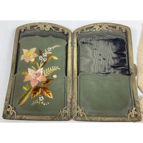 1360 - An Edwardian leather needle case wallet with decorative brass frame and embroidered floral decoratio... 