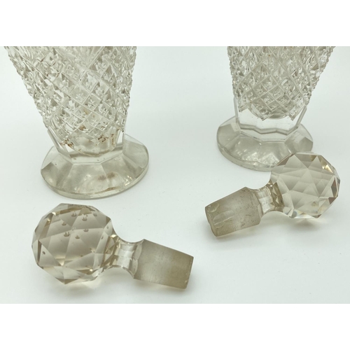 1194 - A pair of early 20th century cut glass scent bottles with silver collars and shoulders. Worn silver ... 